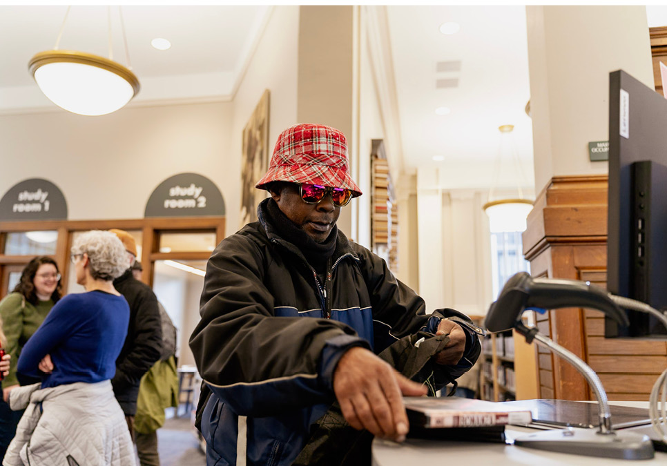 Library patron using self-checkout station at the Green Lake Branch